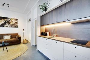 uma cozinha com um lavatório e um sofá num quarto em Pick A Flat's Apartment in Saint-Michel - Rue Pestalozzi em Paris