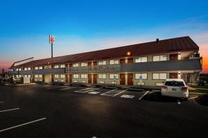 a building with a car parked in a parking lot at Red Roof Inn Chattanooga - Hamilton Place in Chattanooga