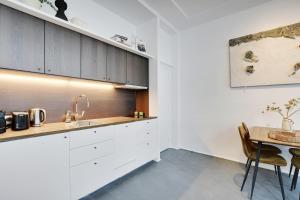 uma cozinha com armários brancos e uma mesa de madeira em Pick A Flat's Apartment in Saint-Michel - Rue Pestalozzi em Paris mais 6 fotografias
