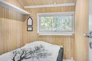 ein Schlafzimmer mit einem Fenster in einer Holzwand in der Unterkunft Little Fiskerbanke - Lovely, Private, And Family-friendly Holiday Home in Saltum