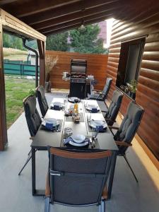 einen Tisch und Stühle auf einer Terrasse mit Grill in der Unterkunft Villa Kum in Tuk Vojni