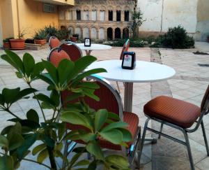 Hotel Colibrì في أليسانو: مجموعة من الطاولات والكراسي في ساحة الفناء