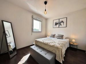 um quarto com uma cama grande e um espelho em Relaxation & Business - Villa T3 near MEETT/Airbus em Aussonne