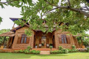 een stenen huis met een boom ervoor bij The Kabok Villa by Vivanya in Ambalangoda