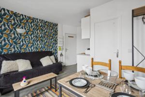 uma sala de estar com um sofá preto e uma mesa em 811 Suite Dream - Superb apartment em Bagnolet