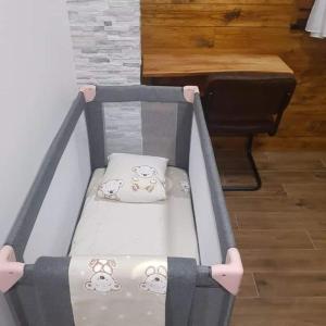 ein Babybett mit Kissen in einem Zimmer mit Klavier in der Unterkunft Villa Kum in Tuk Vojni