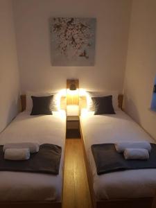 two twin beds in a room with a light on it at Villa Kum in Tuk Vojni