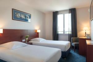 ル・プレシ・ロバンソンにあるプレシ パルク オテルのベッド2台と窓が備わるホテルルームです。