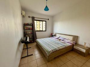 een slaapkamer met een bed en een boekenplank bij Mansa home in Dakar