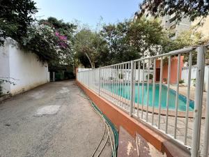 een hek naast een zwembad naast een gebouw bij Mansa home in Dakar