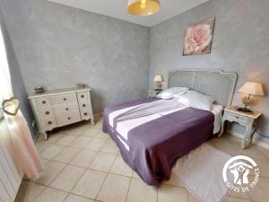 1 Schlafzimmer mit einem Bett mit einer lila Tagesdecke und 2 Tischen in der Unterkunft Gîte Courbeveille, 3 pièces, 6 personnes - FR-1-600-35 