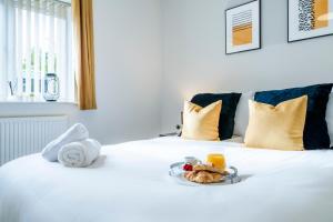 a white bed with a plate of food on it at Pet Friendly with a Hot Tub in Hednesford