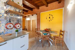 a kitchen with a table and a clock on the wall at Holiday Mulas in Marina di Casalvelino