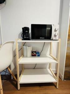 a white shelf with a microwave on top of it at Encantador Apartamento en Pla de l’Ermita in Pla de l'Ermita