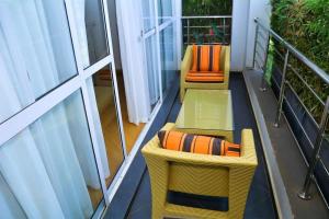 einen Balkon mit 2 Stühlen und einem orangenen Kissen in der Unterkunft The Moon Apartments in Mutomo