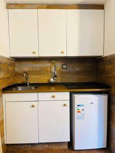 een keuken met witte kasten, een wastafel en een koelkast bij Encantador Apartamento en Pla de l’Ermita in Pla de l'Ermita