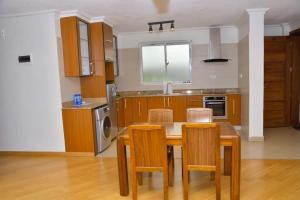 a kitchen with a table and chairs and a sink at The Moon Apartments in Mutomo