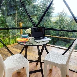 una mesa con un ordenador portátil en un balcón con 2 sillas en RESERVA CATEDRAL Glamping, en Zipaquirá