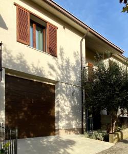 a house with a garage door and a tree at Viasavona46 Nel cuore delle Langhe in Treiso