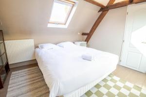 1 cama blanca grande en una habitación con ventana en The Amboisian getaway - Small house for 2 people., en Amboise