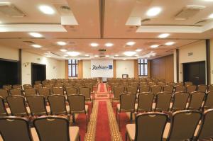 a conference room with rows of chairs and a screen at Radisson Blu Hotel, Gdańsk in Gdańsk
