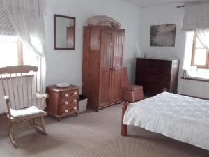 sypialnia z łóżkiem, krzesłem i komodą w obiekcie Gîte La Roche-Neuville, 6 pièces, 14 personnes - FR-1-600-148 w mieście Loigné-sur-Mayenne