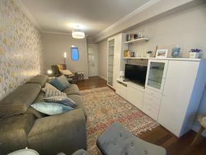 uma sala de estar com um sofá e uma televisão em Casco Viejo junto a BilboRock em Bilbau
