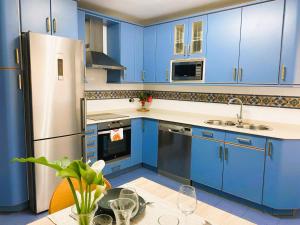 uma cozinha com armários azuis e um frigorífico de aço inoxidável em Casco Viejo junto a BilboRock em Bilbau
