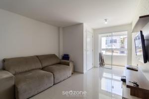 a living room with a couch and a tv at Apto c/ varanda loc. privilegiada em BC BFH0101 in Balneário Camboriú +19 photos