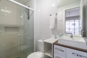 a bathroom with a shower and a sink and a toilet at Apto c/ varanda loc. privilegiada em BC BFH0101 in Balneário Camboriú