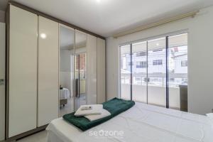 1 dormitorio con cama y ventana grande en Confortável apto em Balneário Camboriú BFH0101, en Balneário Camboriú
