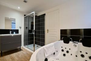 Das Bad ist mit einer Badewanne und einer Dusche ausgestattet. in der Unterkunft NG SuiteHome - Lille l Tourcoing l Haute - Duplex 4 pers - Balnéo - Netflix - Wifi in Tourcoing