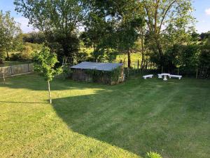 a yard with two picnic tables in the grass at Charmant gîte 2 pers avec terrasse privative et proche Vélo Rail - FR-1-426-466 in Commequiers