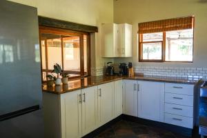 a kitchen with white cabinets and a window at Lucca House in Musina