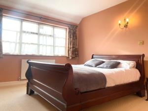 a bedroom with a large bed and a window at The wellbeing XCAPE Country Barn PT & Masseur - H in Nuneaton