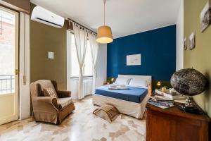 una camera con un letto e una sedia di Exclusive Deluxe Apt Between DUOMO & SAN SIRO a Milano