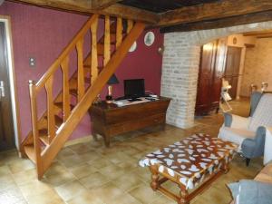 a living room with a staircase and a desk with a television at Gîte Cusey, 3 pièces, 4 personnes - FR-1-611-5 in Cusey