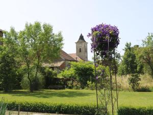 Gîte Saint-Blin, 5 pièces, 9 personnes - FR-1-611-31 في Saint-Blin: كنيسة بها برج به زهور أرجوانية في ساحة