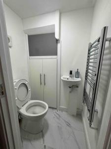 a white bathroom with a toilet and a sink at The Ideal Beautiful 3-Bed House in Birmingham in Birmingham