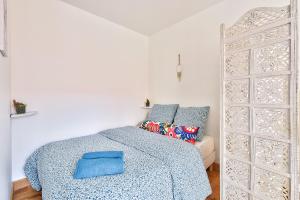 a bedroom with a bed with a blue blanket at Budget studio with parking - The river seine in Saint-Denis