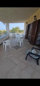 um quarto com mesas e cadeiras numa varanda em Villa Greco em Cirella
