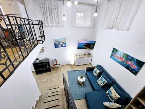 een woonkamer met een blauwe bank en een trap bij Lovely duplex Apartment Cismigiu Park - POP1 in Boekarest