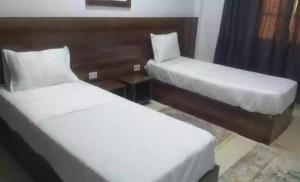 2 camas en una habitación de hotel con faldas en hotel amilcar tataouine, en Tataouine