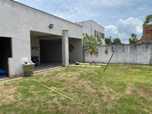 een tuin met een betonnen gebouw en een hek bij Casa 1km praia in São Mateus