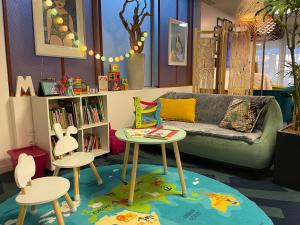 a living room with a couch and a table and stools at Mercure Toulouse Centre Saint-Georges in Toulouse