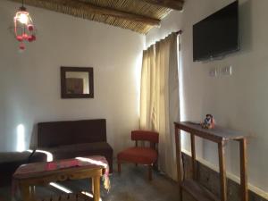 a living room with a couch and a tv on the wall at 4 ELEMENTOS in Huacalera