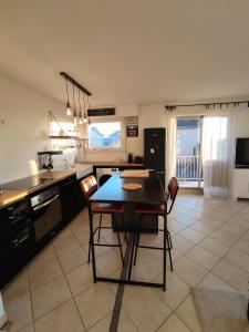 サン・ミシェル・シェフ・シェフにあるIdéal en amoureux, vue mer et jardin ! Appartement lumineux à Tharon-Plageの部屋にテーブルと椅子のあるキッチン