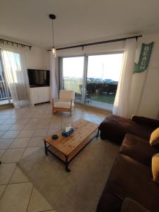 サン・ミシェル・シェフ・シェフにあるIdéal en amoureux, vue mer et jardin ! Appartement lumineux à Tharon-Plageのソファとコーヒーテーブルのあるリビングルーム