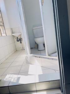 a bathroom with a toilet and a sink at Sunrise Guest Inn in Pretoria