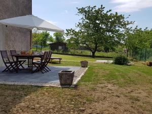 un patio con mesa y sombrilla en Gîte Removille, 3 pièces, 4 personnes - FR-1-589-370, en Rémoville